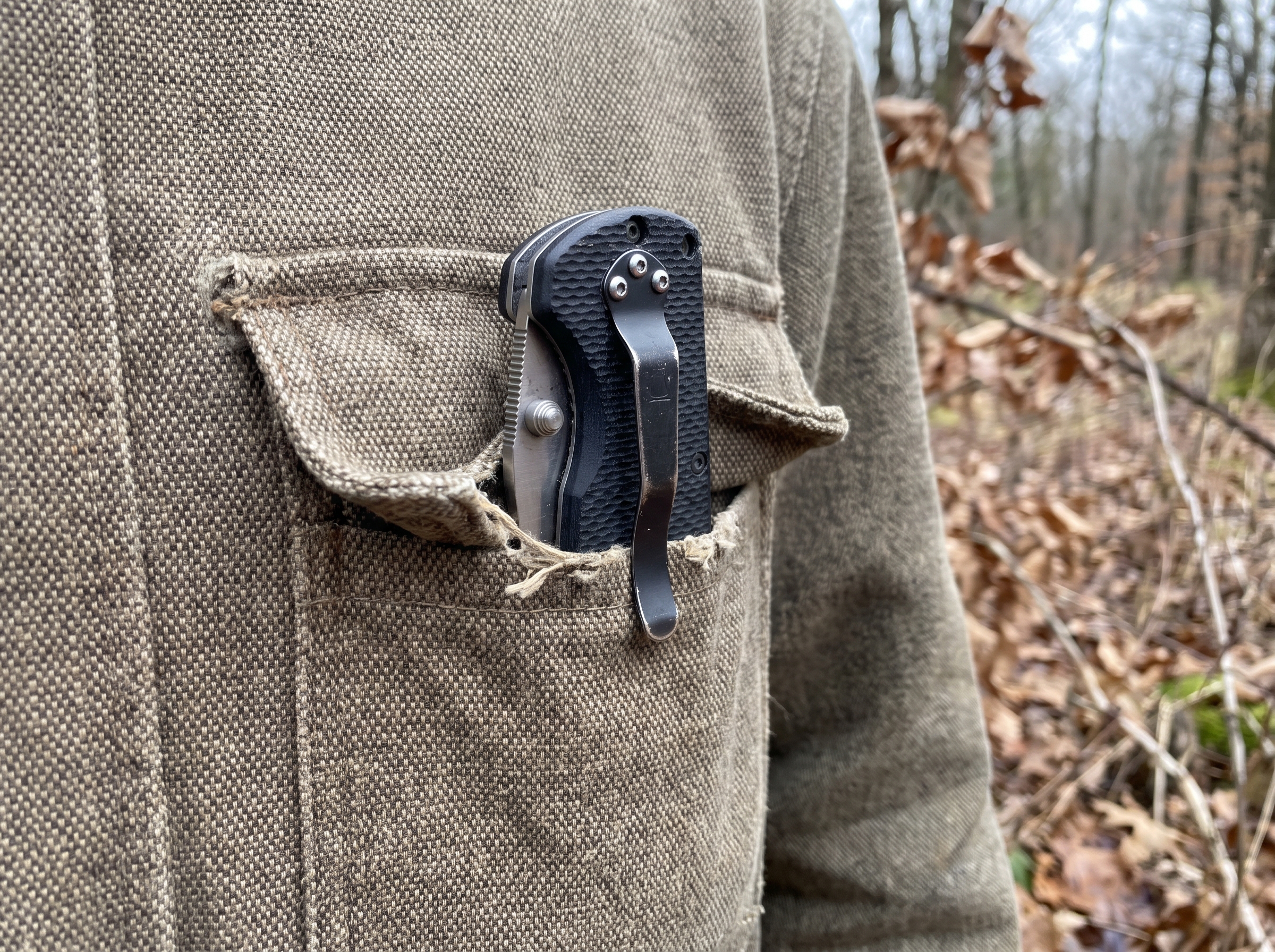 Couteau pliant compact rangé dans une poche de veste de chasse